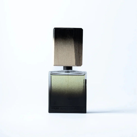 Perfume bottle with a metallic cap on a light gray background